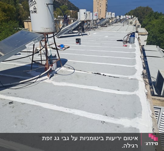 גג עם איטום לבן בין לוחות בטון אפורים